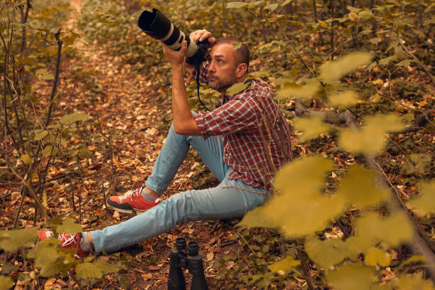 istock Man using binoculars and camera for birdwatching and other observing animals in nature. 1742354457