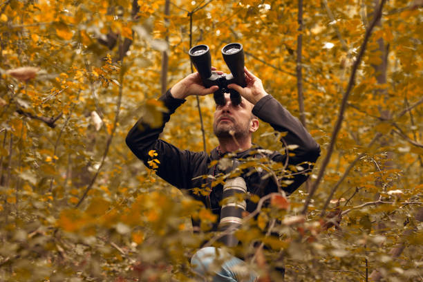 istock Man using binoculars and camera for birdwatching and other observing animals in nature. 1742355006
