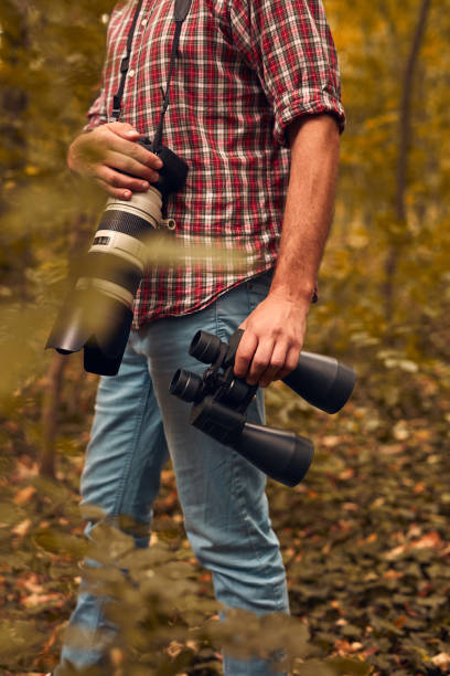 istock Man using binoculars and camera for birdwatching and other observing animals in nature. 1742355015