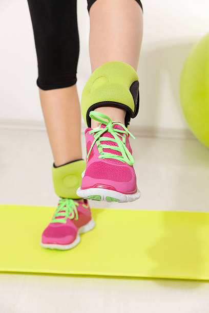 Woman with ankle weights and pink jogging shoes stock photo