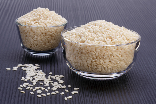white rice in glass bowl on dark wooden table