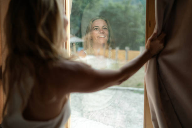 Happy woman open curtains welcome new day