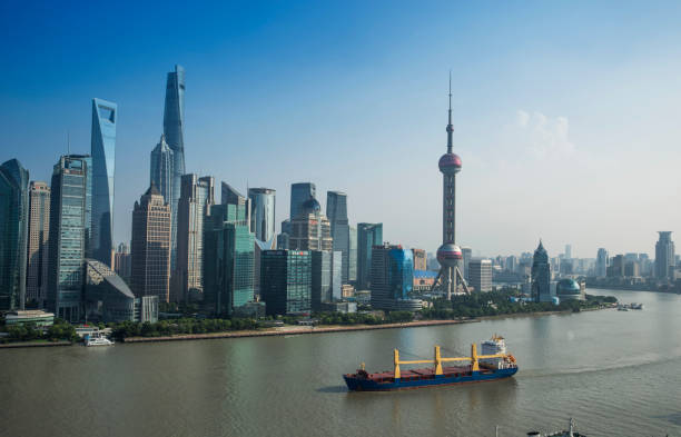 Mid-air view of Shanghai Pudong Cityscape with Freightships cruising on the Huangpu River on a hazy, foggy day. Shanghai, China