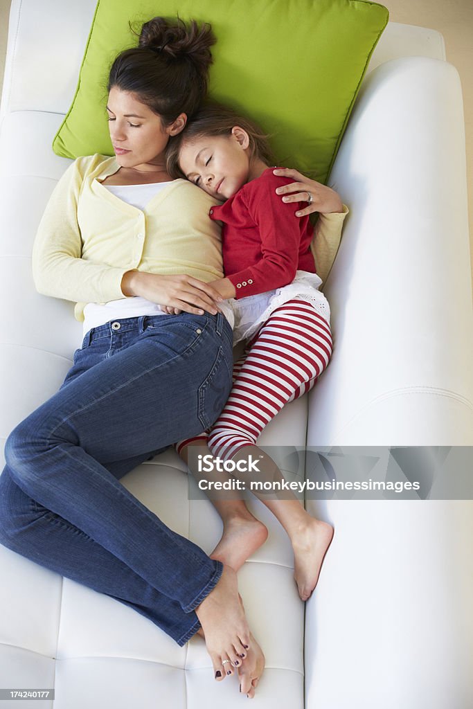 Overhead View Of Mother And Daughter Relaxing On Sofa Overhead View Of Mother And Daughter Relaxing On Sofa Together, Asleep 20-29 Years Stock Photo