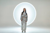 Young woman in front of a circular light shape