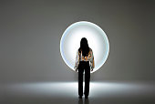 Young woman in front of a circular light shape