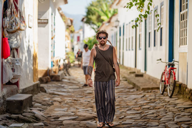 istock Young man with dreadlocks walking down an old cobblestone street 1742411056