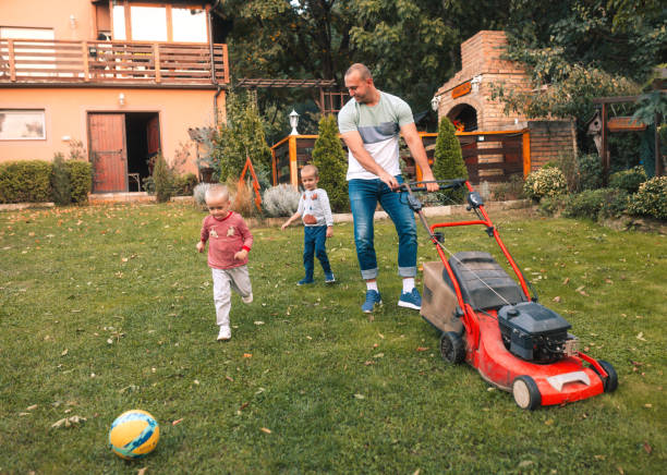 istock the children are playing in the yard while dad is mowing the grass 1742432008