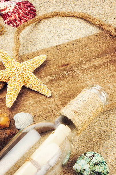 istock Old wooden board with seashells and bottle 174243933