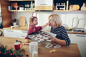 Little girl eating homemade gingerbread cookies for Christmas
