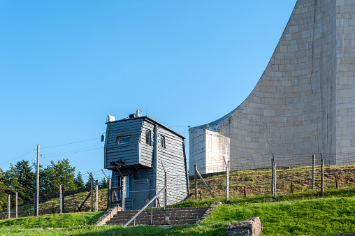 Natzwiller, France - September 14, 2021: Watchtower of former Natzweiler-Struthof concentration camp, behind it Lighthouse of Remembrance memorial. Bas-Rhin department in Alsace region of France