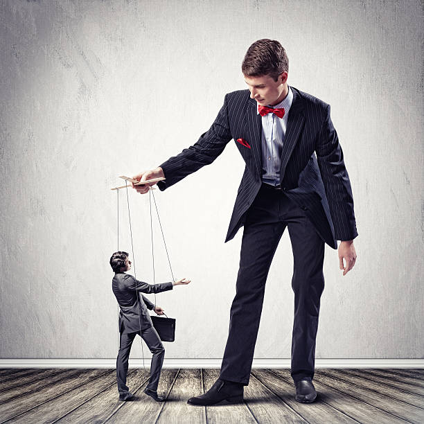 Businessman is being a puppeteer Image of young businessman puppeteer. Leadership concept puppet master stock pictures, royalty-free photos & images