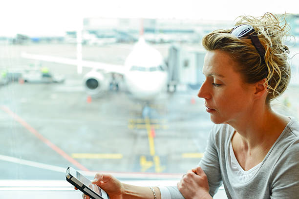 istock 40 y.o. woman using smartphone at the airport 174247556