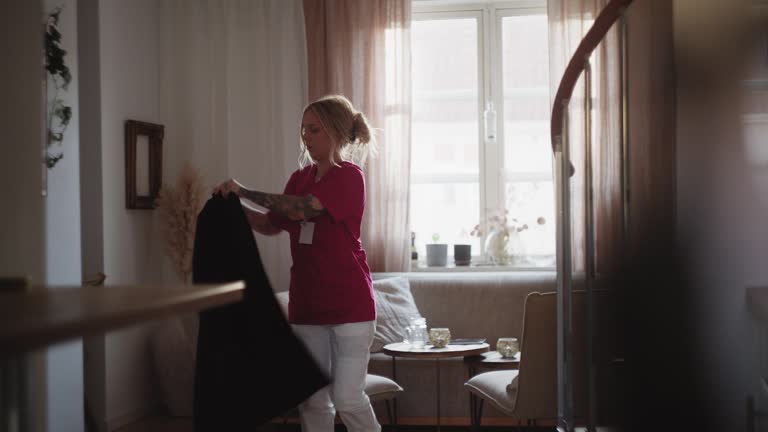 Woman preparing to leave her apartment, putting on her jacket