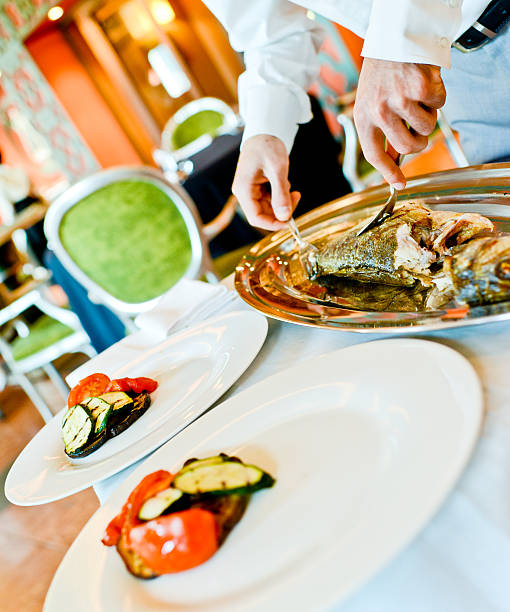 istock Waiter preparing grilled fish to be served 174248270