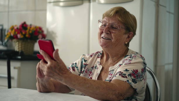 istock Elderly Woman Using Cellphone Device in Home Kitchen 1742494489