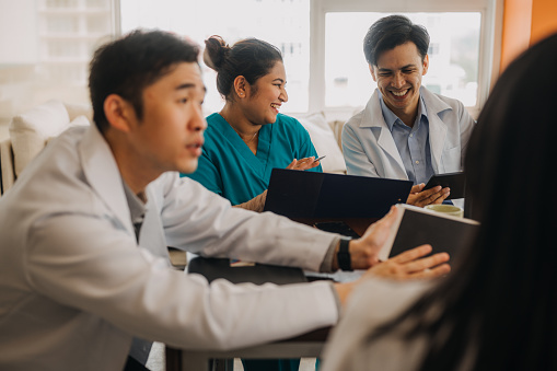 Group of medical specialists communicating while having a meeting in the hospital. Medical team or board reviewing hospital financial information.