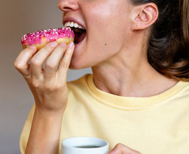istock Smiling woman eating pink coloured donut. 1742527733