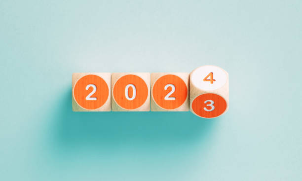 2023年と2024年の青緑色の背景にオレンジ色の立方体