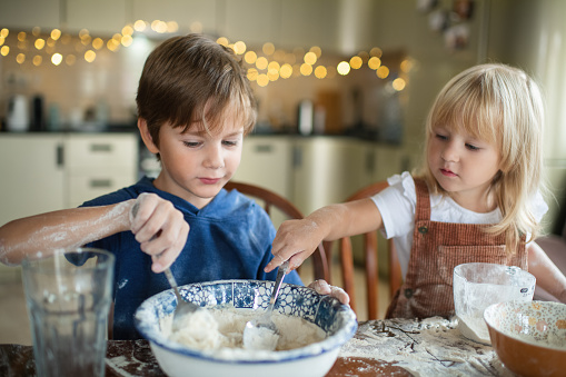 Little boy and girl cooking at home