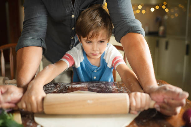 istock Family rolling up dough for a cake pizza at the kitchen 1742562105