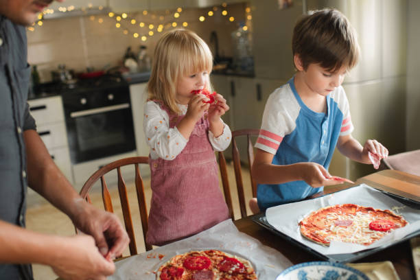 Family making pizza at the kitchen stock photo