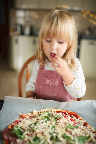 istock Cute little girl making pizza at the kitchen 1742564461