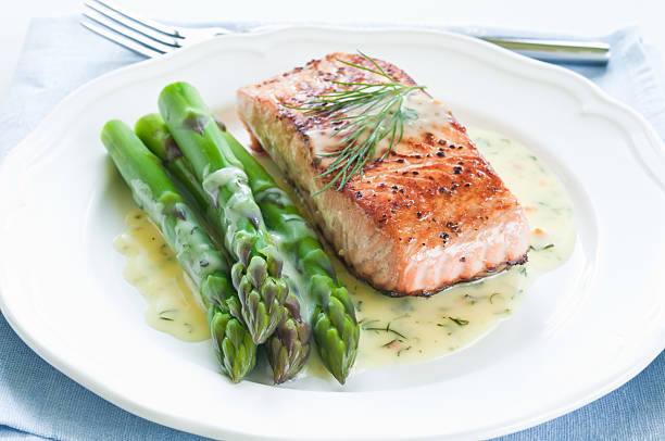 Salmon with Asparagus Grilled salmon with asparagus and dill sauce on white plate grilled salmon stock pictures, royalty-free photos & images