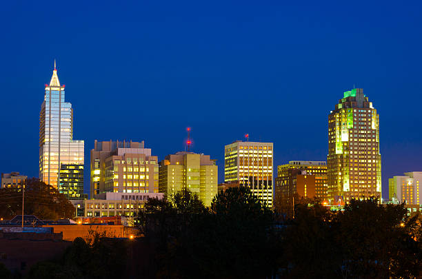 Raleigh skyline at dusk Downtown Raleigh at dusk with the reflection of the sunset on the glass windows of the buildings. raleigh north carolina stock pictures, royalty-free photos & images