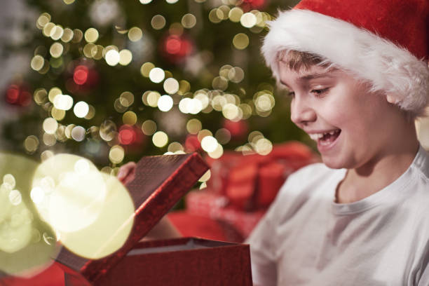 istock Joyful boy in a Santa hat opens a Christmas present. Boxing day. Christmas Eve Magic night 1742599467