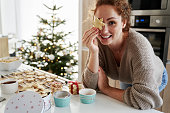 Caucasian woman covering eyes with gingerbread cookies
