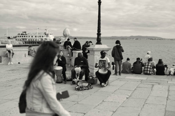 Lisbon, Portugal - Mars 11, 2023: A trio of street musicians play percussion y the Tagus River in Lisbon downtown.