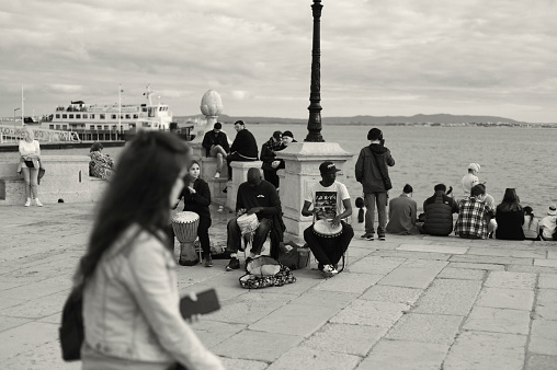 Lisbon, Portugal - Mars 11, 2023: A trio of street musicians play percussion y the Tagus River in Lisbon downtown.