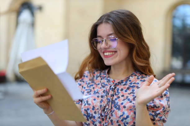 istock A young woman, happy and cheerful, reading a document for her education. 1742663553