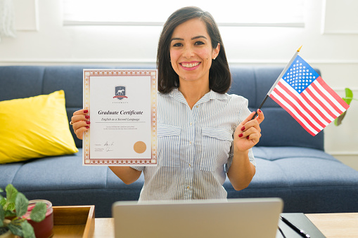 Smiling cheerful woman holding the US flag while getting her certificate after learning English online