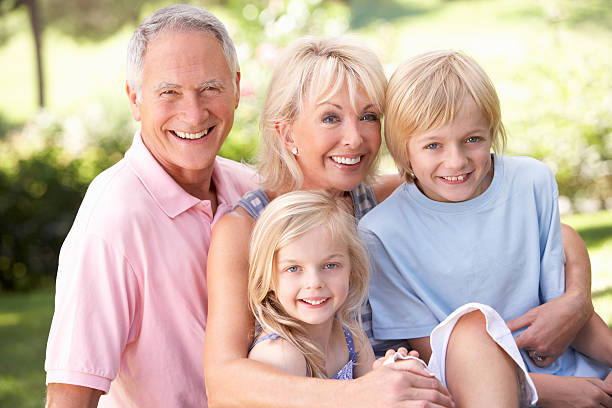istock Senior couple with children posing in park 174270090