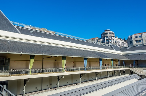 Porto, Portugal – September 19, 2023: A traditional old-style building stands adjacent to a stone bridge, with a river or lake in the background