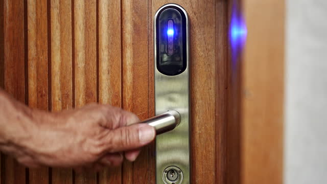 Close-up Hand of Man using proximity card, contactless digital key to opening door of room in hotel. Digital or keyless to authenticate.