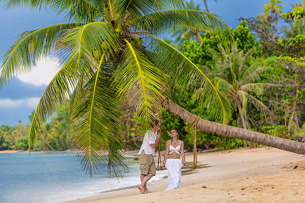 istock Happy couple sitting on the sunny beach 174273767