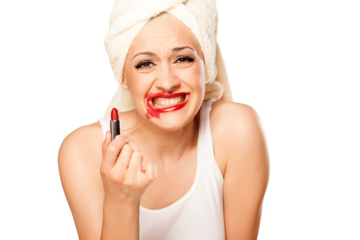 smeared all over the lips blonde with a towel on her head holding a lipstick in hand