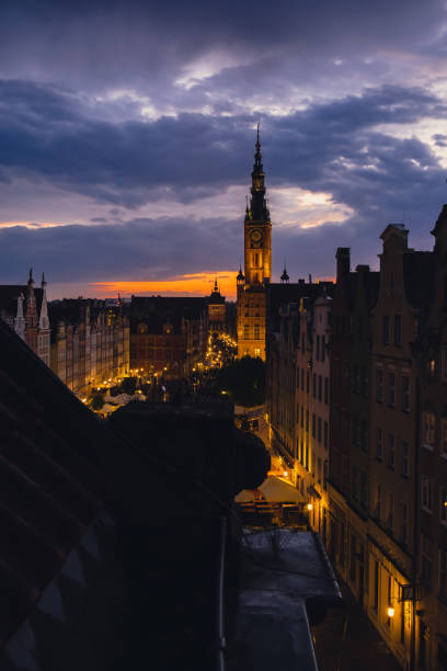 Beautiful old town in Gdansk at summer dusk Poland. Sunset night view from the window rooftop on historical centre Dluga street and city hall architecture buildings St Mary Basilica. Travel attraction tourist destination Dramatic sky hermoso casco antiguo en gdansk al atardecer de verano polonia. vista nocturna del atardecer desde la azotea de la ventana en el centro histórico de la calle dluga y los edificios de arquitectura del ayuntamiento de la basílica de santa maría. atracció