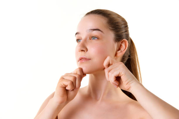 istock Young attractive girl doing hand massage for face looking away isolated against white studio background. Model with well-kept skin. 1742770868