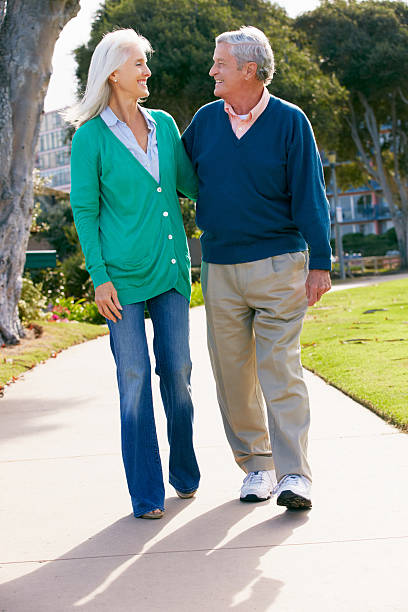 istock Senior Couple Walking In Park Together 174277608