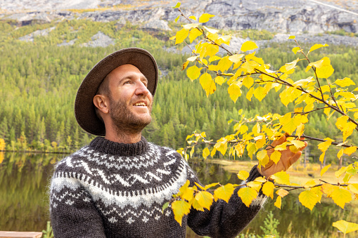 Man enjoying peaceful environment in Norway. Lake and green mountains.
Autumn season