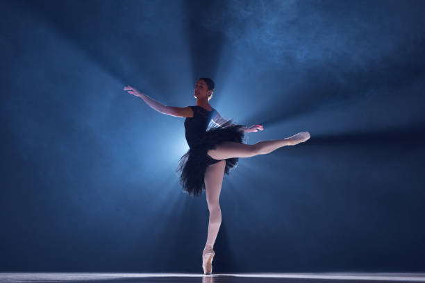 istock Elegant performance. Beautiful young woman, professional ballet dancer n motion, dancing over blue background with smoke 1742805262
