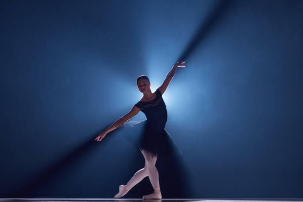 istock Elegant performance. Beautiful young woman, professional ballet dancer n motion, dancing over blue background with smoke 1742806429