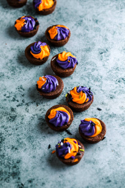 istock Brownie cupcakes with ghost cream decor and sprinkles on a slate board on a gray background. Happy Halloween concept. American culture and traditions 1742822066