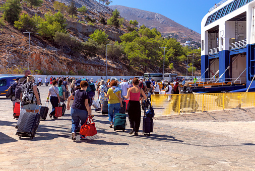 Symi, Greece - September 18, 2023: Passengers board the sea ferry Blue Star on a sunny morning.