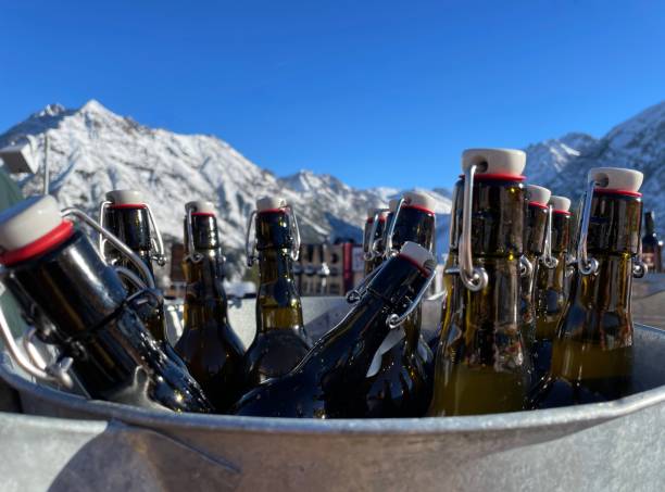 apres esquia en los alpes austríacos. botellas de cerveza en un cubo en un día soleado. marca, vorarlberg, austria. - apres ski friendship skiing enjoyment fotografías e imágenes de stock