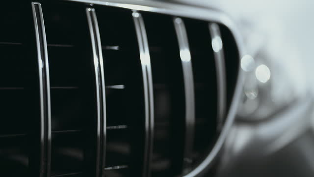 Close-up camera pan shiny reflective metallic surface of a brand new car grilles